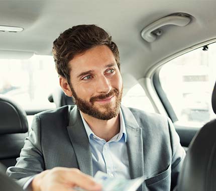 Hombre ejecutivo viajando en Taxi Premium